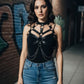 Black chain-detail leather body harness worn by a model in an urban alley.