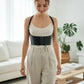 Black vegan-leather underbust corset belt with lace-up front and shoulder straps worn by a model.
