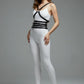 HarnessClub black vegan leather multi-band body harness with chest ring and waist belts worn over a white bodysuit.