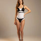 HarnessClub black studded vegan leather bralette and brief set; two-piece worn over white base bodysuit.