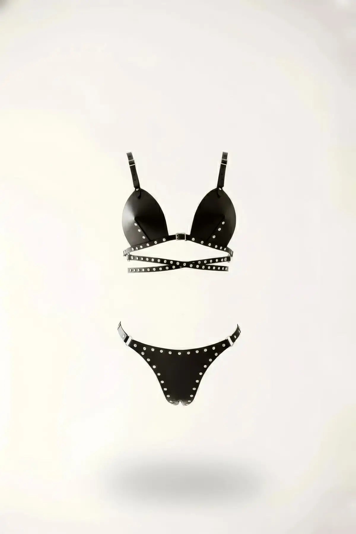 Black studded vegan leather bralette and thong set with harness-style straps.