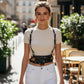 HarnessClub black studded waist-panel harness worn over a white ribbed top; vegan leather accessory.