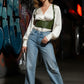 Khaki lace-up underbust corset belt with straps in olive vegan leather on a model wearing a white blouse.