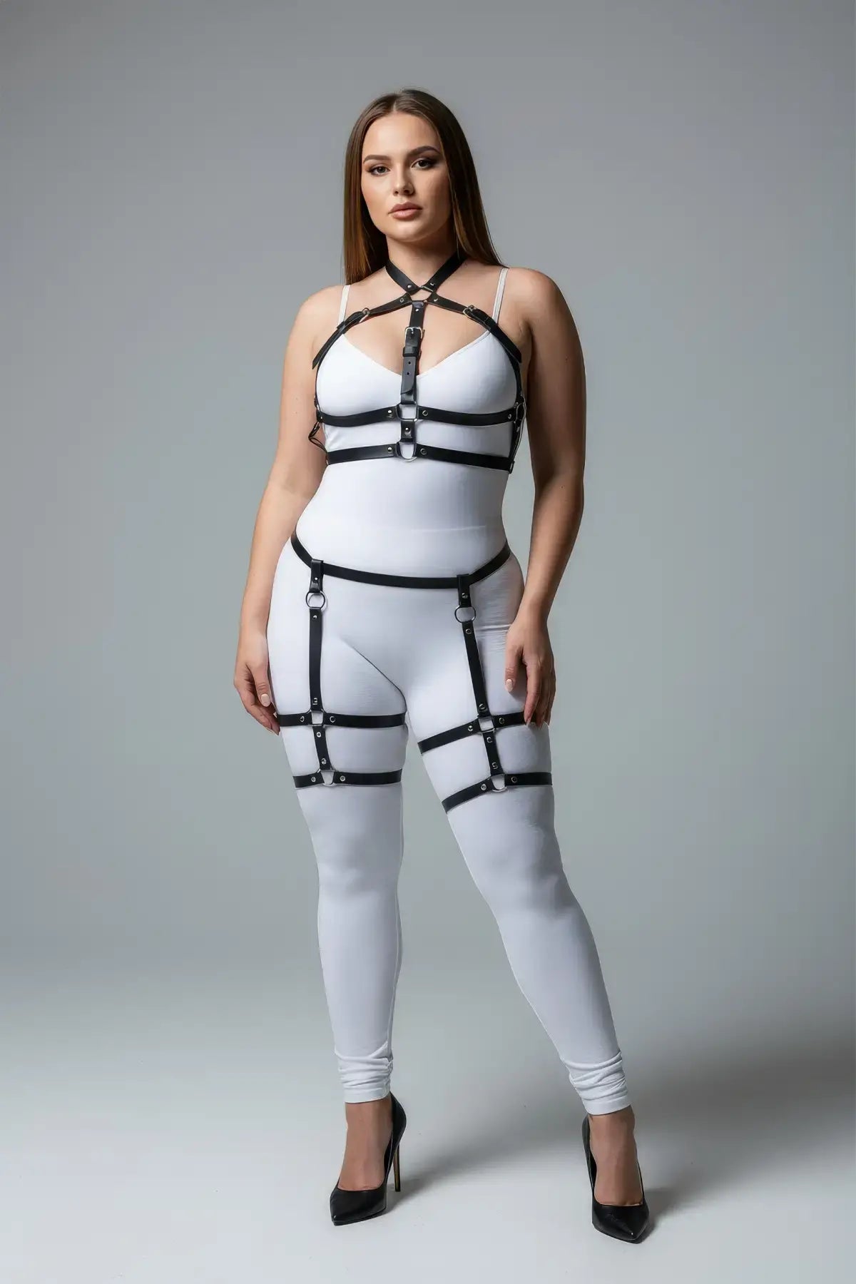 Plus Size Black Adjustable Garter Harness Set by HarnessClub in faux leather worn over a white bodysuit.