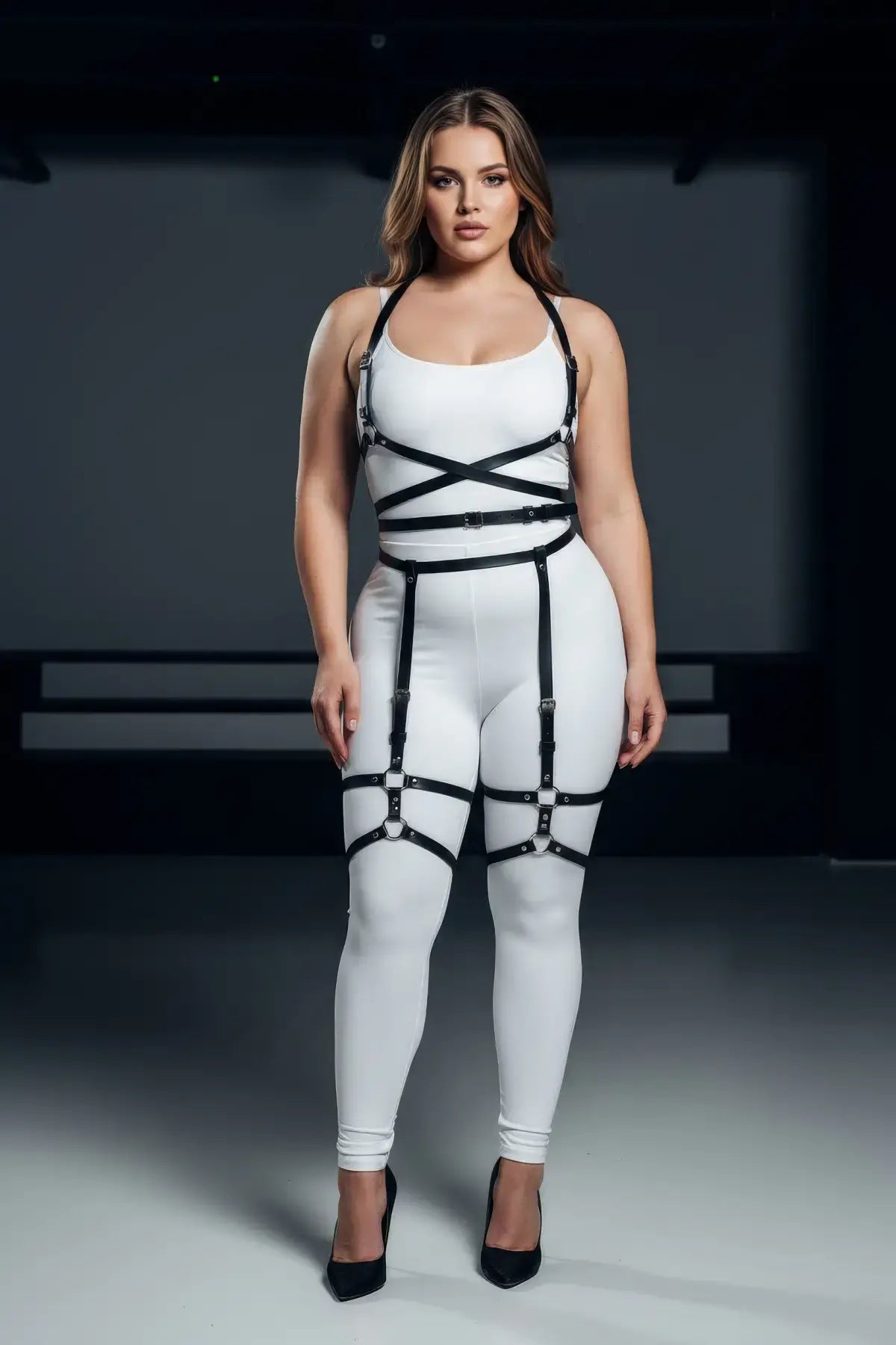 Plus-size garter harness bodysuit with black faux-leather straps on white base