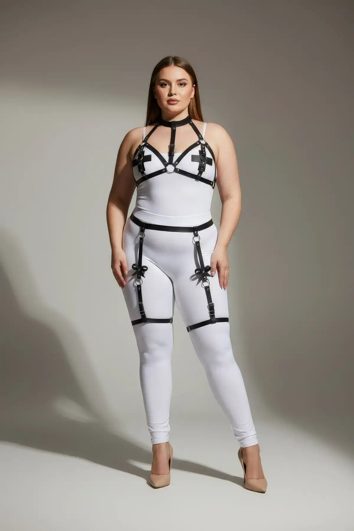 Plus-size white bodysuit with black faux-leather harness and garter straps.