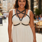Plus-size black cage chest harness by HarnessClub, vegan leather over-dress body accessory worn over a white dress.