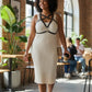 Plus-size black cage chest harness over beige ribbed dress, HarnessClub vegan leather accessory.