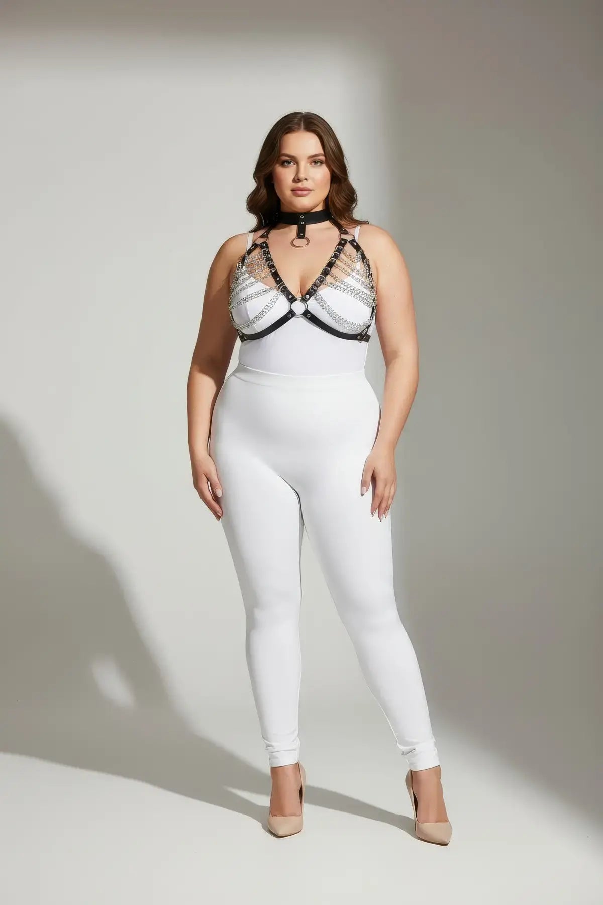 Plus-size black faux-leather body harness with chain and collar worn over a white outfit; HarnessClub