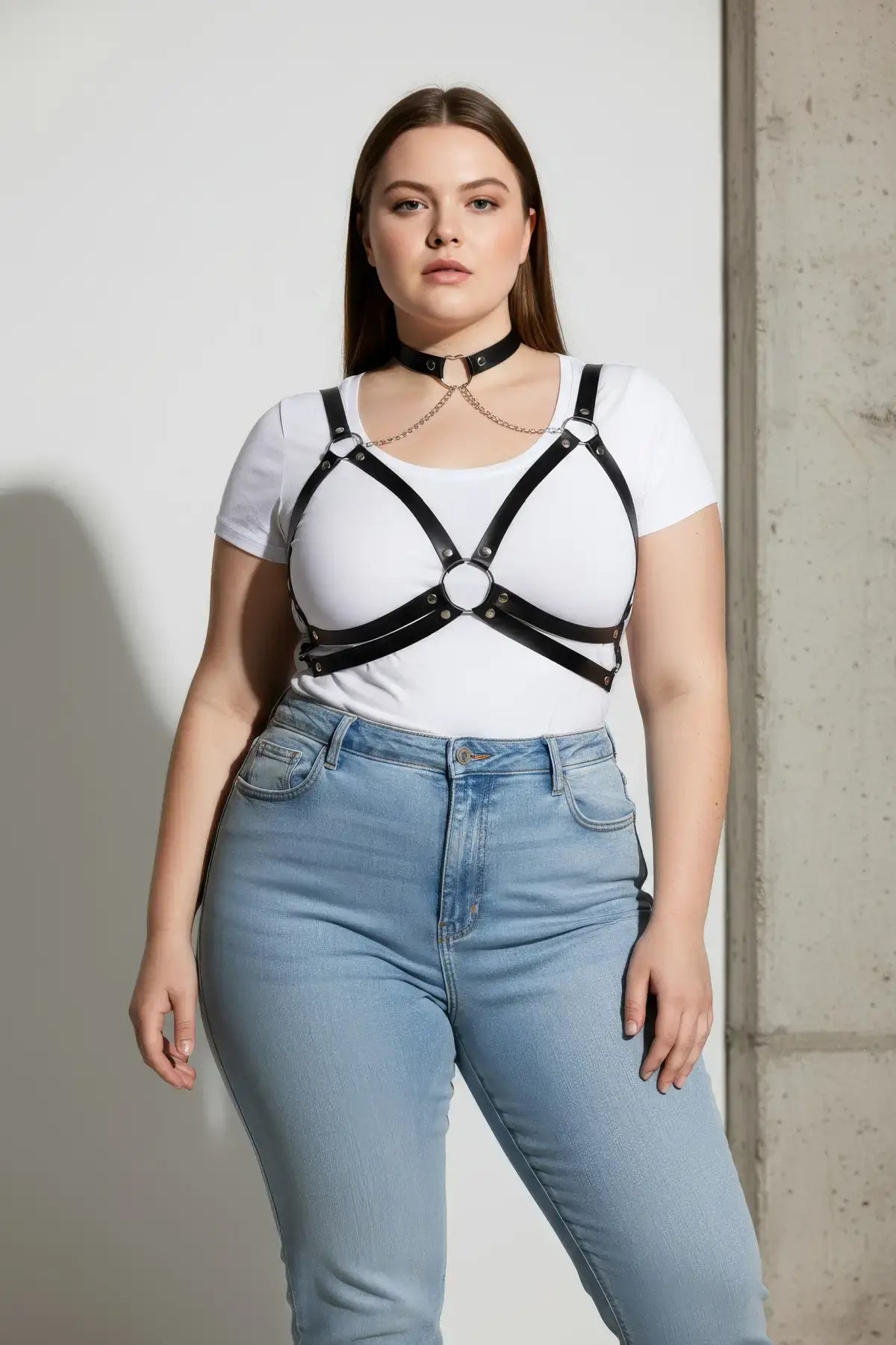 Plus-size black vegan leather chain cage chest harness worn over a white T-shirt