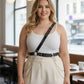 Plus-size black chain-detail body harness with metal buckles worn over a white tank top