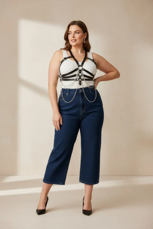 Plus-size black vegan leather chain-detail corset harness worn over a white top