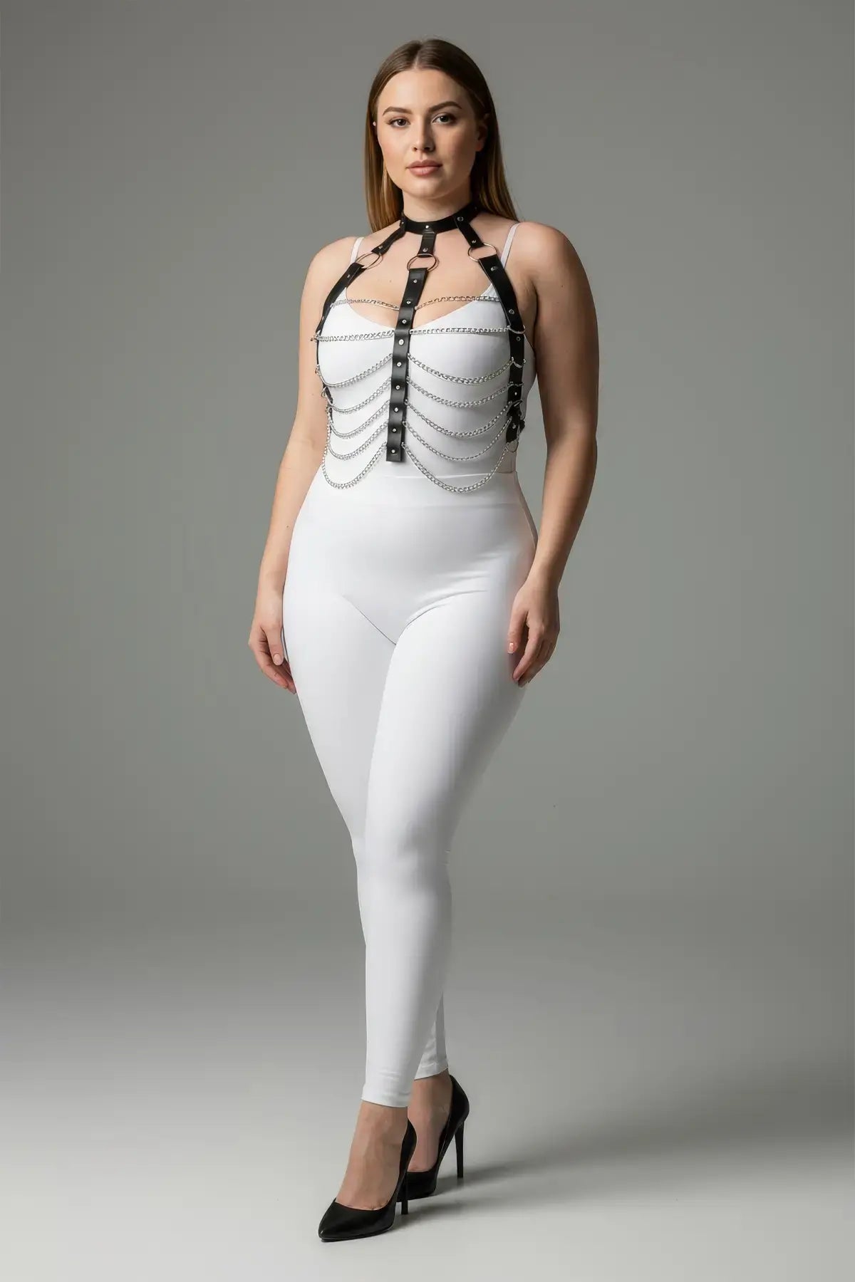 Plus size black chain-detail faux leather harness worn over a white bodysuit.