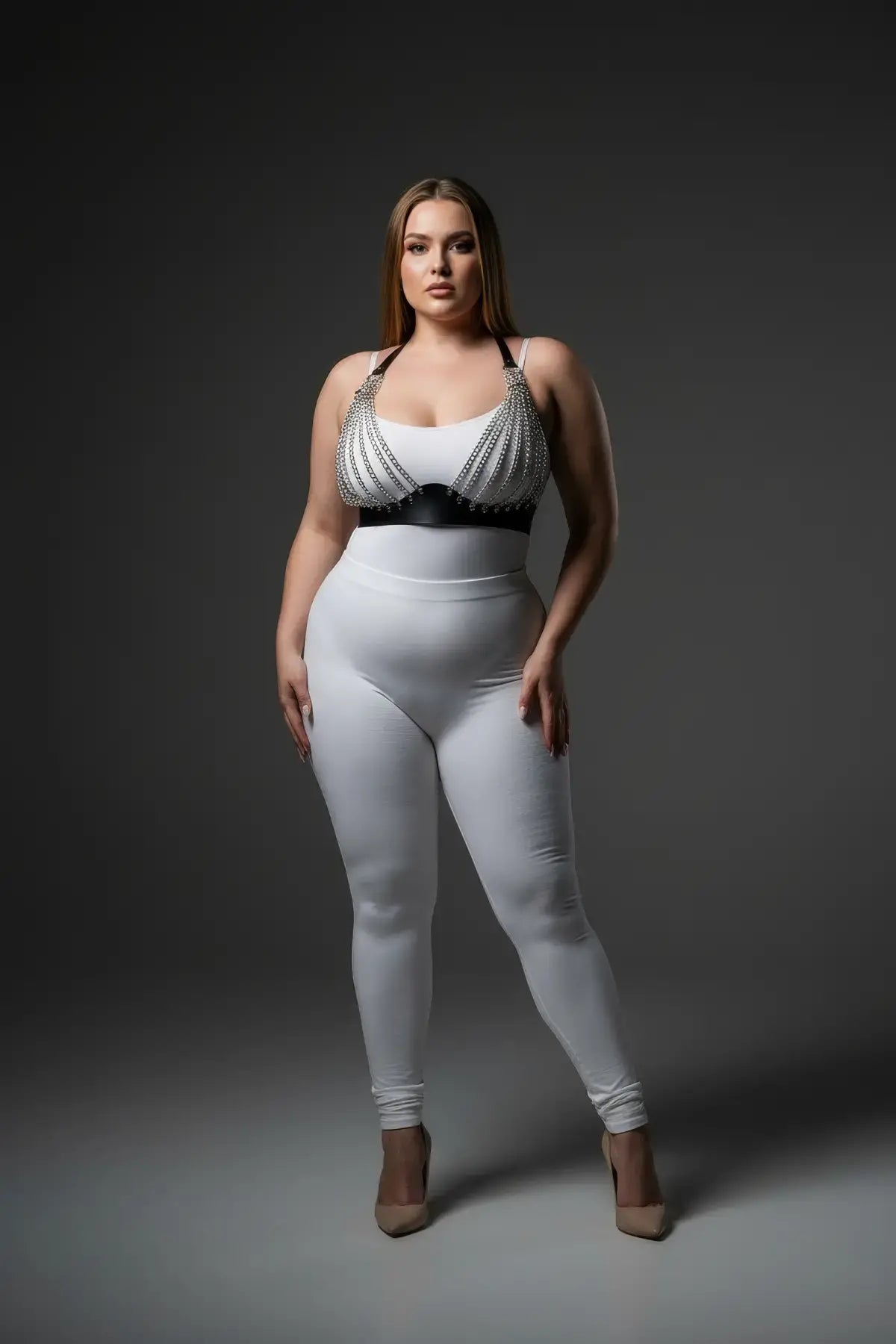 Plus-size black chain-detail faux leather harness top with silver chains, worn over a white bodysuit.