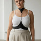 Plus Size Black Chain-Detail Leather Body Belt by HarnessClub with metal ring and chain accent worn over a white top