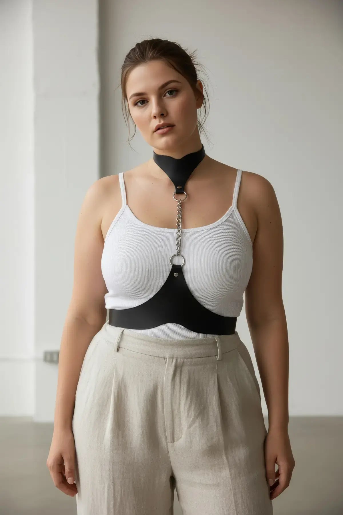 Plus Size Black Chain-Detail Leather Body Belt by HarnessClub with metal ring and chain accent worn over a white top