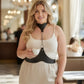Plus size black leather body belt with chain detail worn at the waist, connected to a neck-chain collar via metal ring.