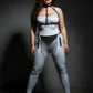 Plus-size black chain-drape and fringe vegan leather harness set on a model; silver chains drape across the chest and waist.