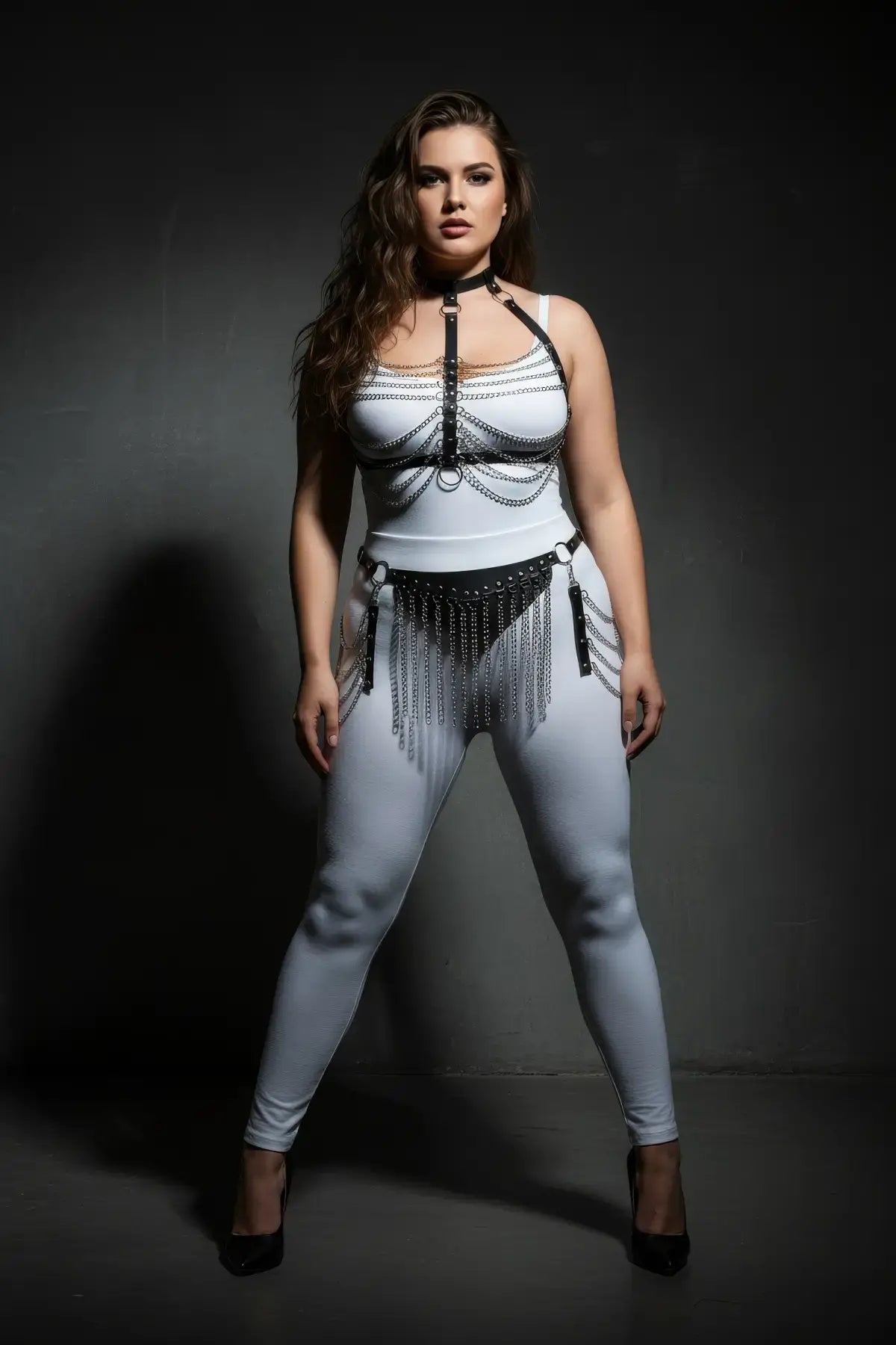 Plus-size black chain-drape and fringe vegan leather harness set on a model; silver chains drape across the chest and waist.