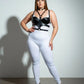 Plus-size black faux leather choker and chest harness set on model with white bodysuit and black heels