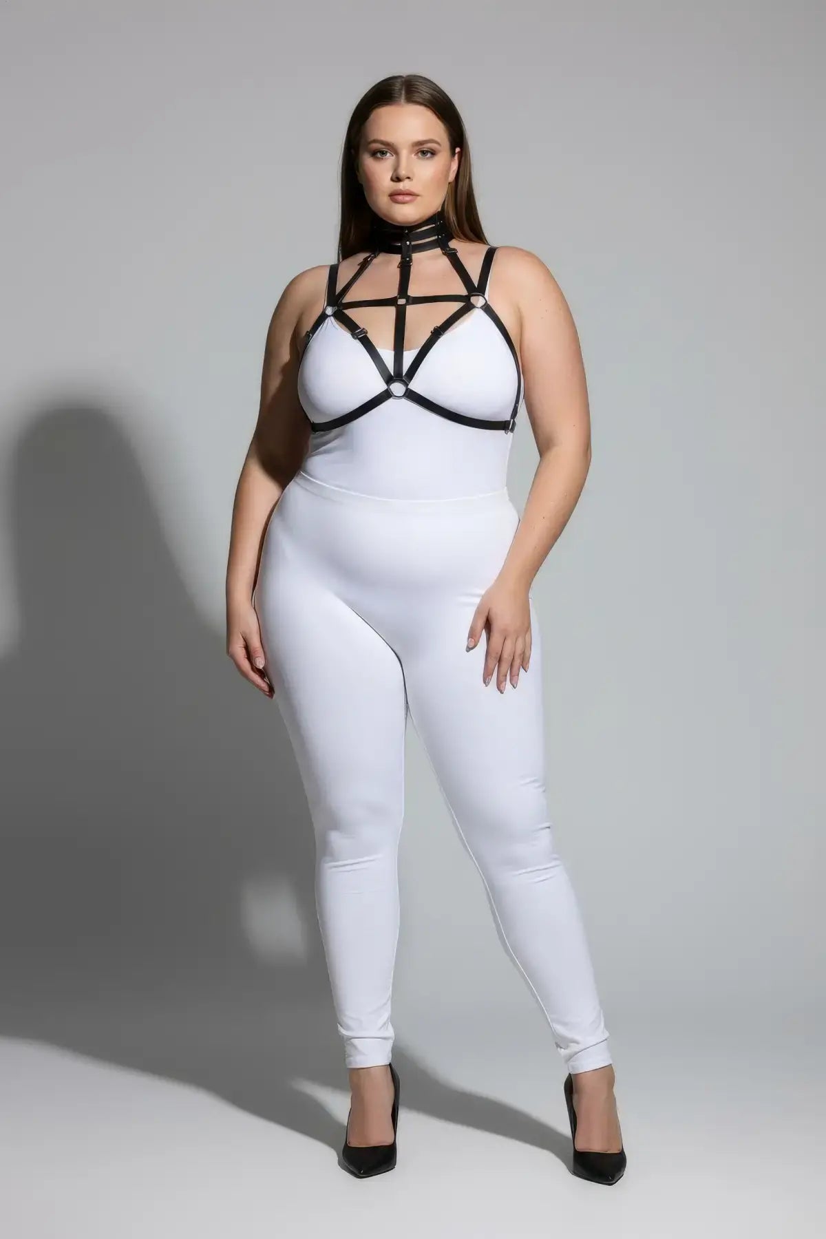 Plus size black choker-cage elastic chest harness worn over a white bodysuit.