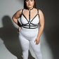 Plus-size black faux-leather harness set with collar and O-rings worn over a white bodysuit