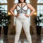Plus-size black faux-leather harness with collar and O-ring straps worn by model in a white bodysuit