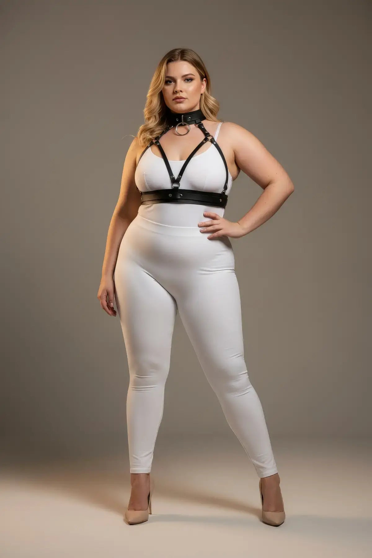 Plus-size black faux-leather harness with collar detail worn over a white bodysuit.