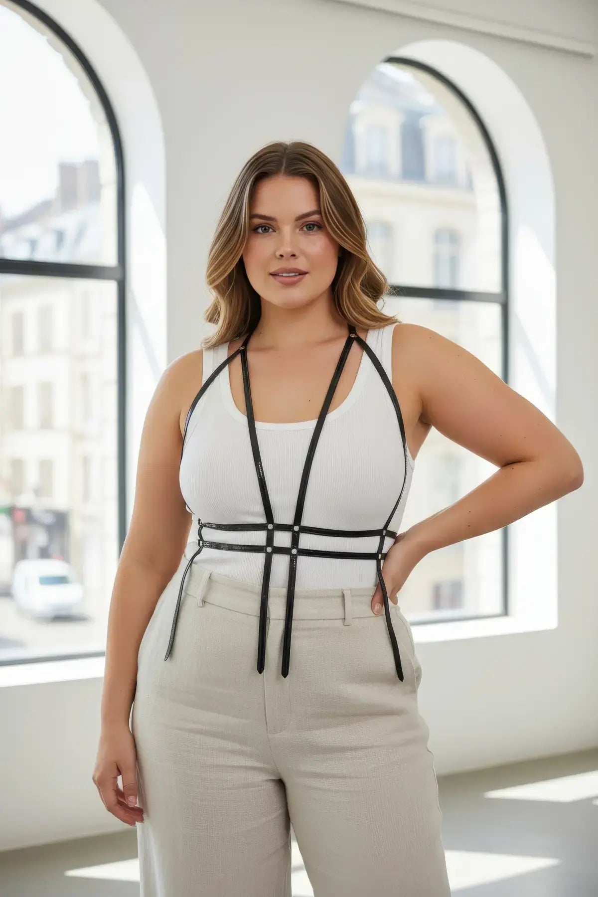 Plus size black corset body harness by HarnessClub with layered straps, worn over a white tank top