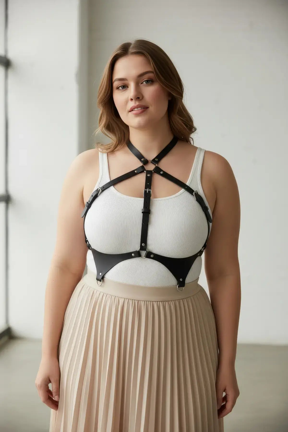 Plus size black leather corset-style body harness worn over a white tank top