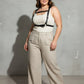 Plus size black corset-style leather body harness worn over a white tank top.