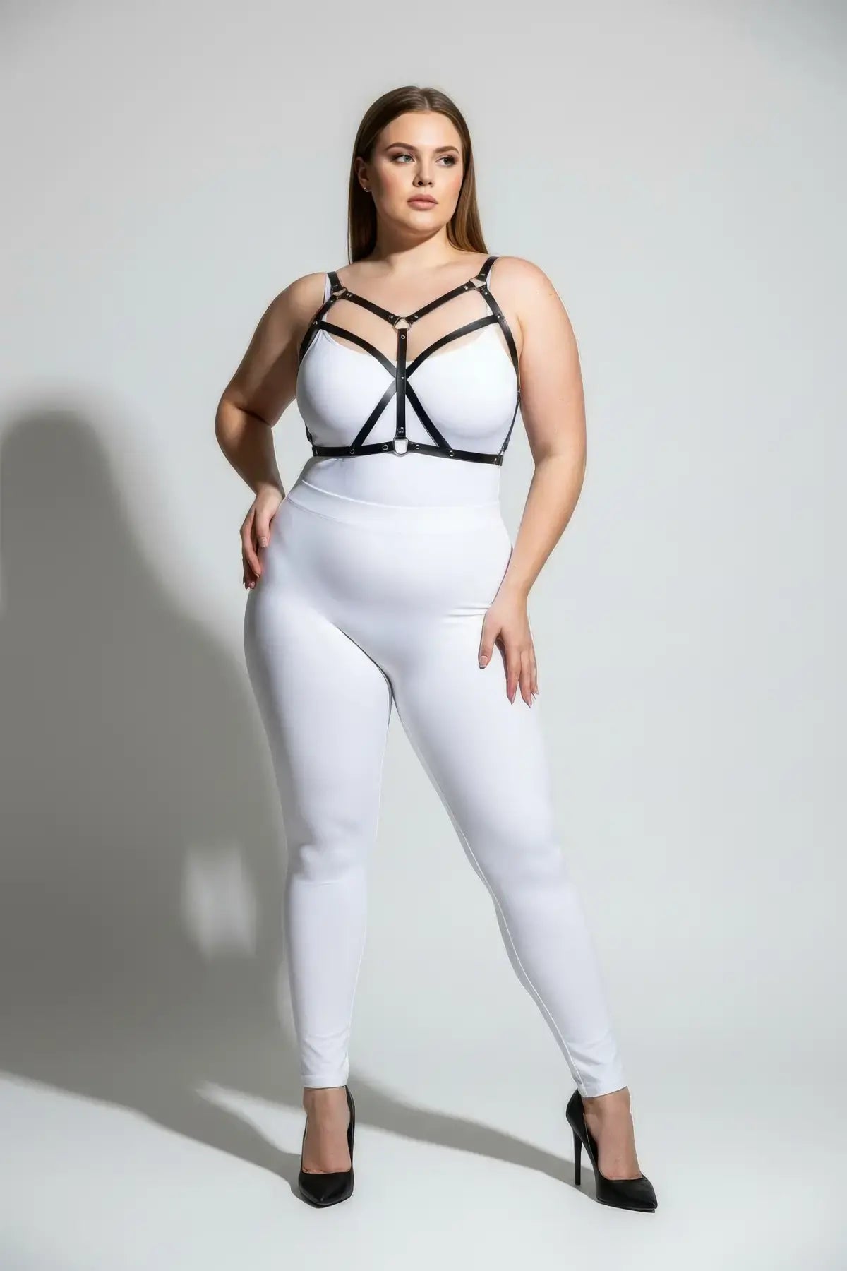 Plus-size black faux-leather cross-strap bustier harness over white top