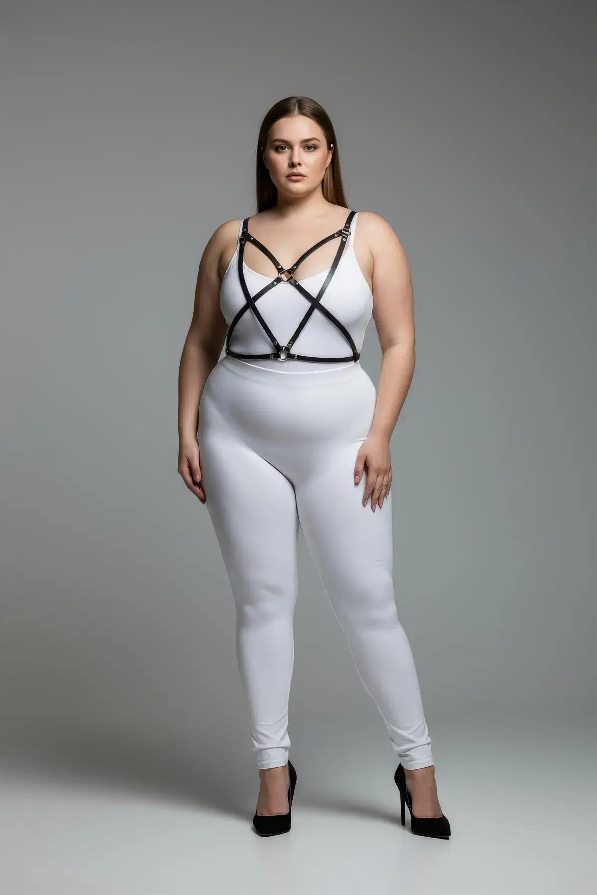 Plus-size black cross-strap faux leather body harness worn over a white outfit