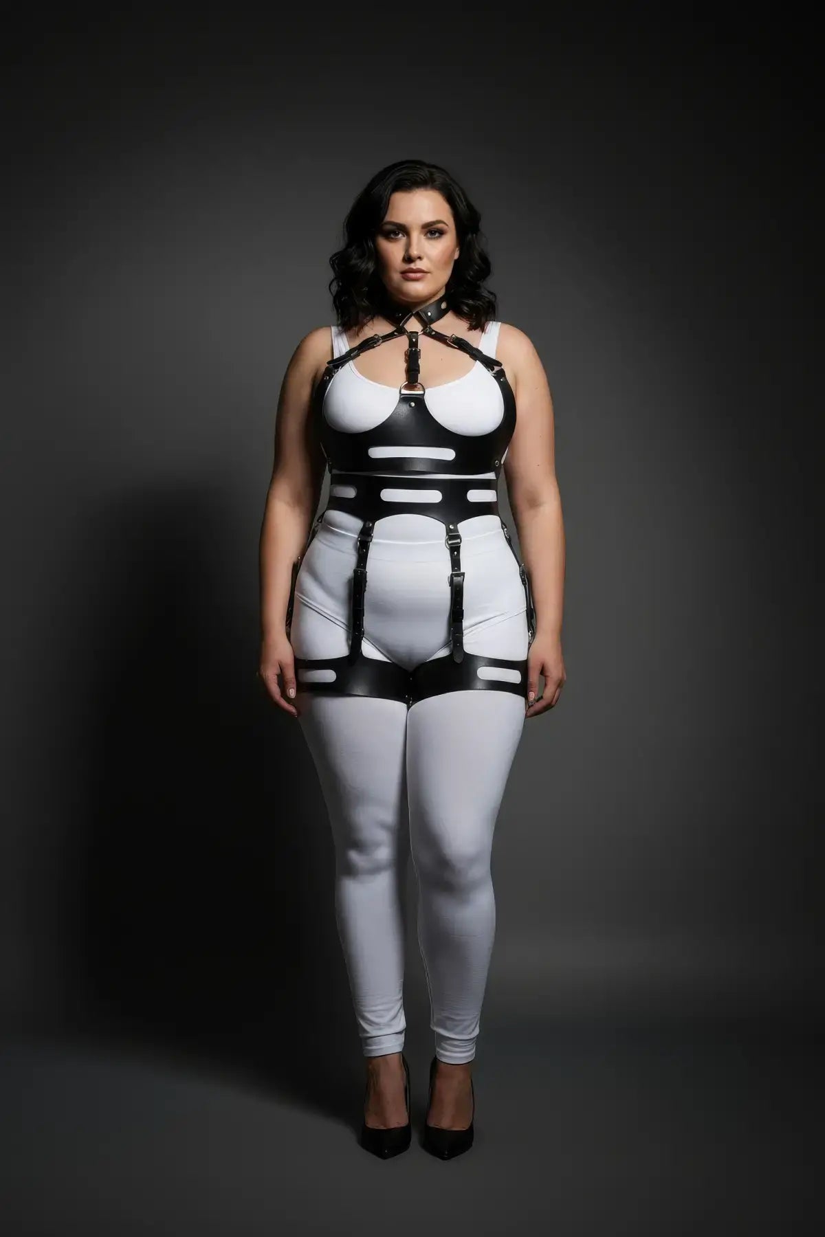 Plus-size black cutout-panel harness bodysuit with halter collar on a white base, vegan leather.