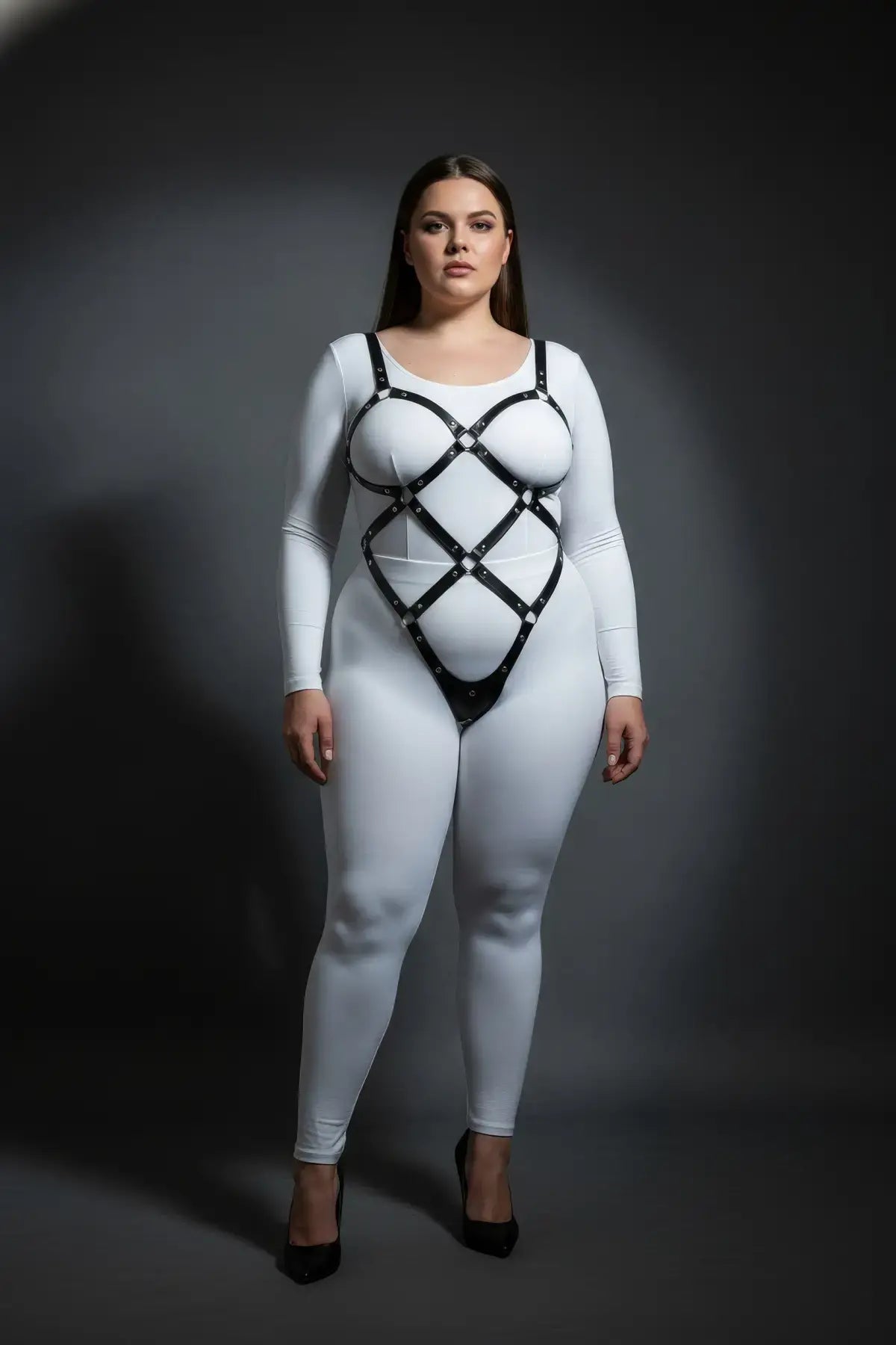 Plus size black diamond lattice body cage harness by HarnessClub in vegan leather worn over a white bodysuit.