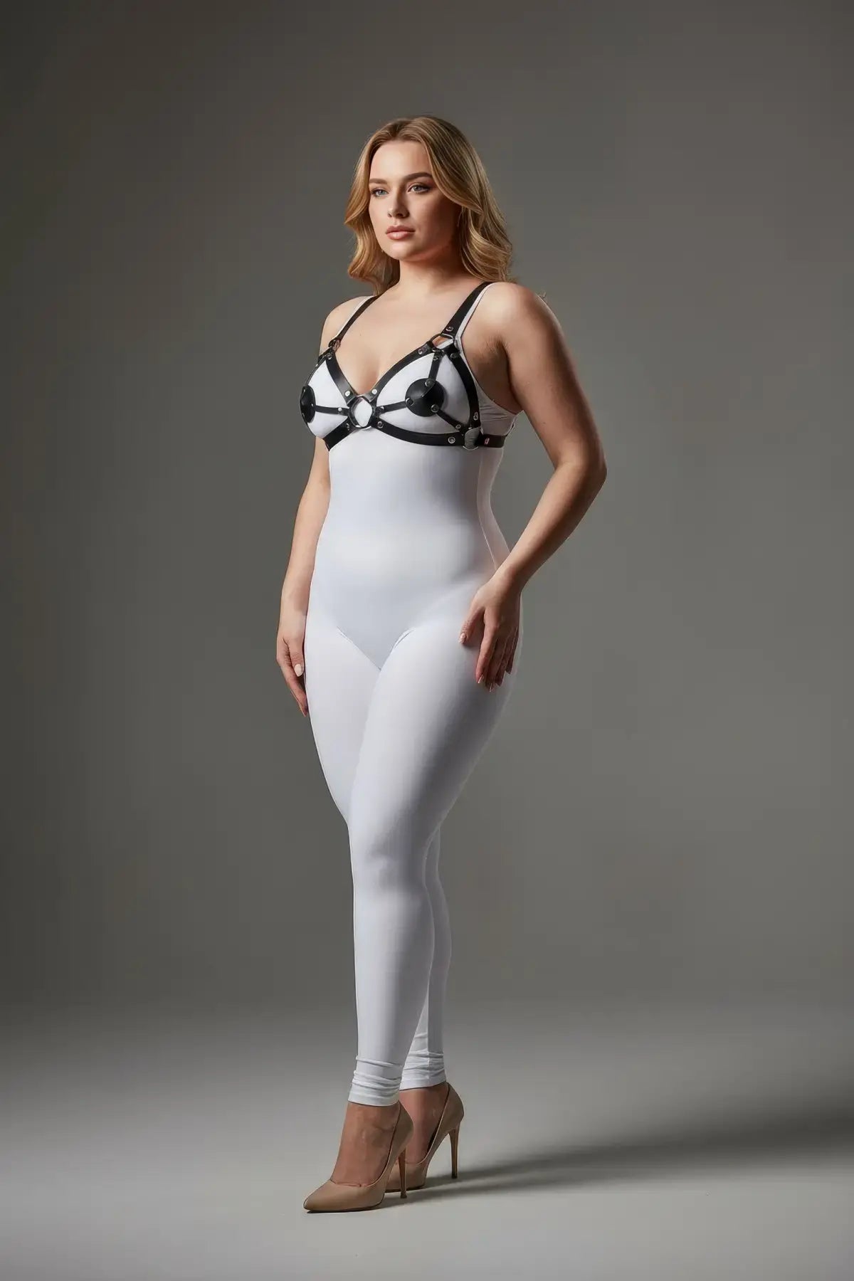 Plus size black disc O-ring vegan leather chest harness by HarnessClub over a white bodysuit