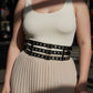Plus-Size black vegan leather belt with double-row grommets and three buckles worn at waist by HarnessClub