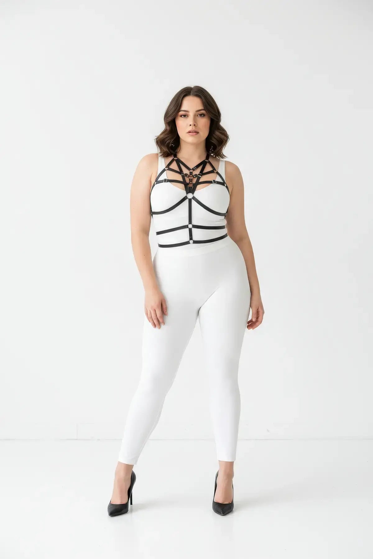 Plus-size black elastic cage chest harness with front O-ring, worn over a white top