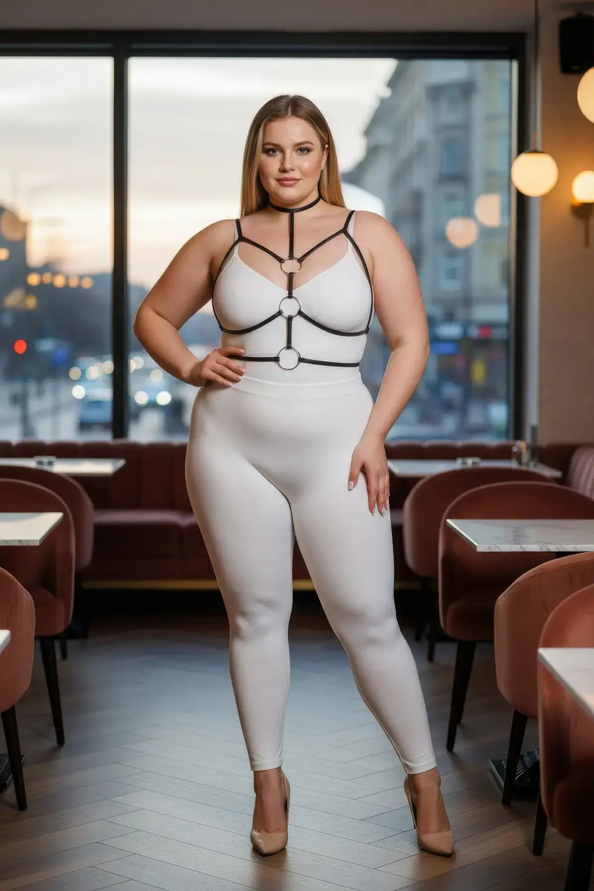 Plus-size black elastic collar and O-ring harness over a white bodysuit worn by a plus-size model