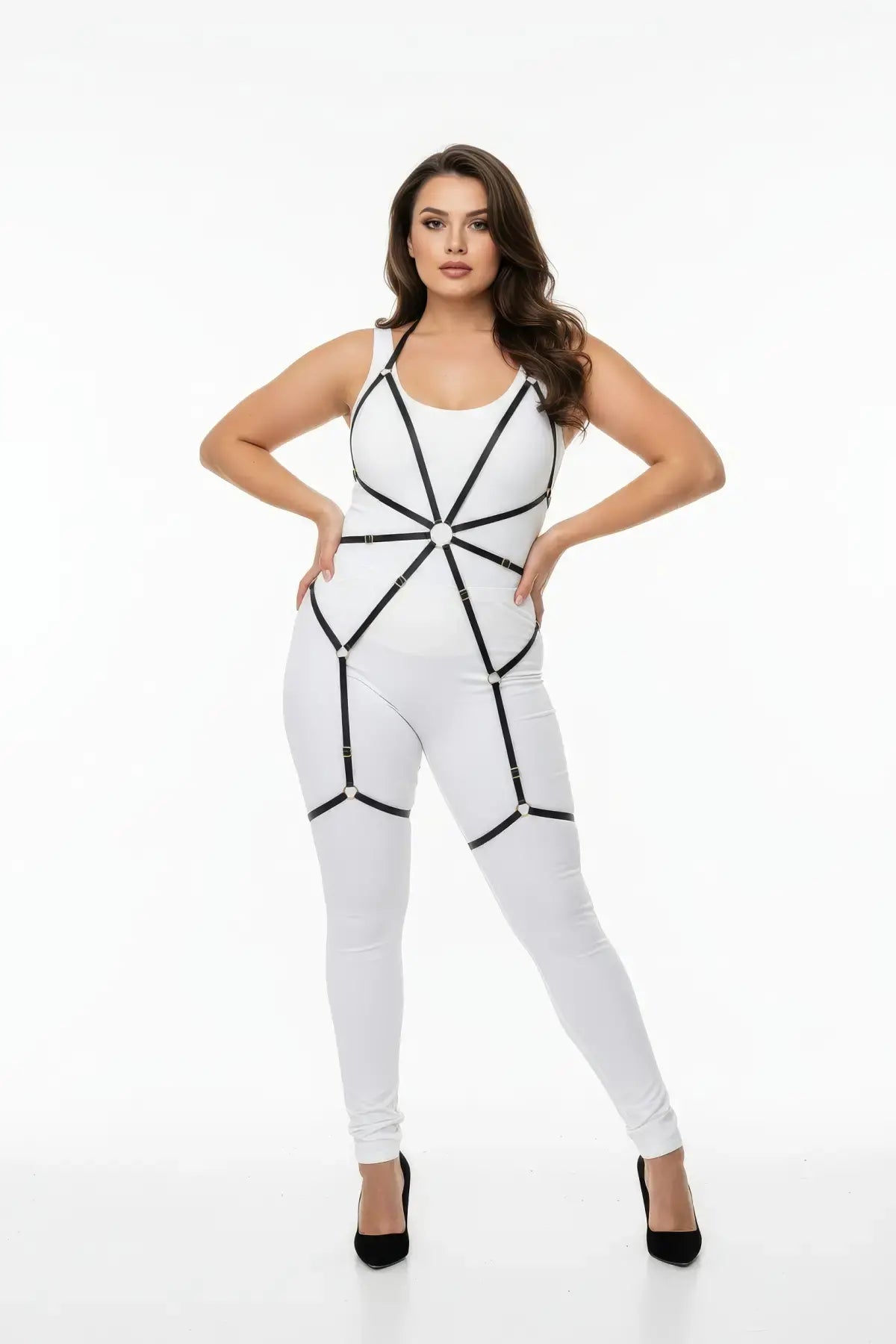 HarnessClub plus-size black elastic full-body garter harness with O-rings worn over a white bodysuit.