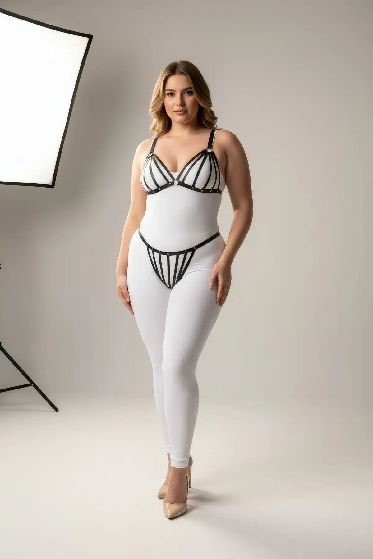Plus Size Black Elastic Multi-Strap Fantasy Harness by HarnessClub worn over a white bodysuit