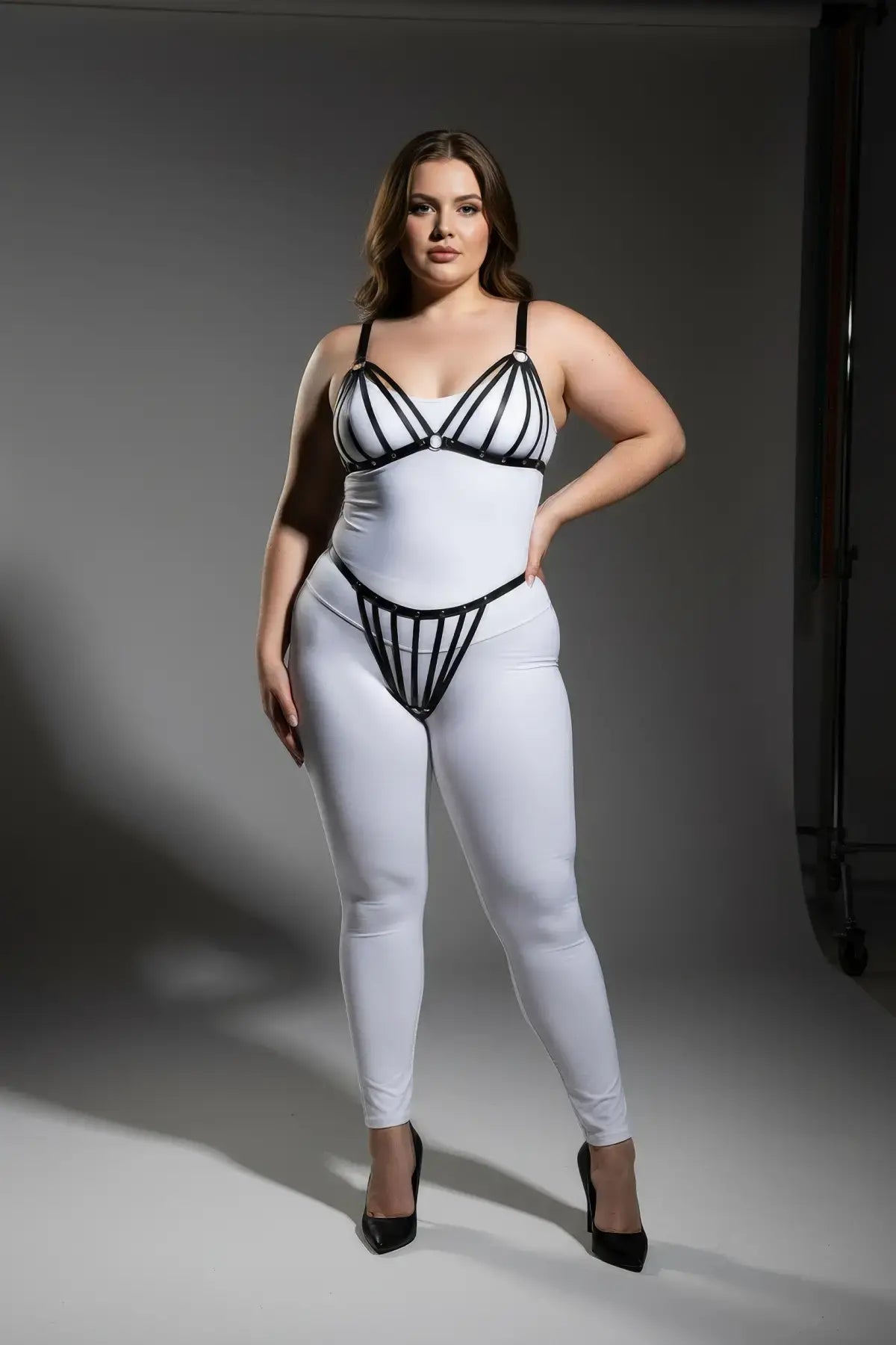 Plus Size Black Elastic Multi-Strap Fantasy Harness by HarnessClub worn over a white bodysuit