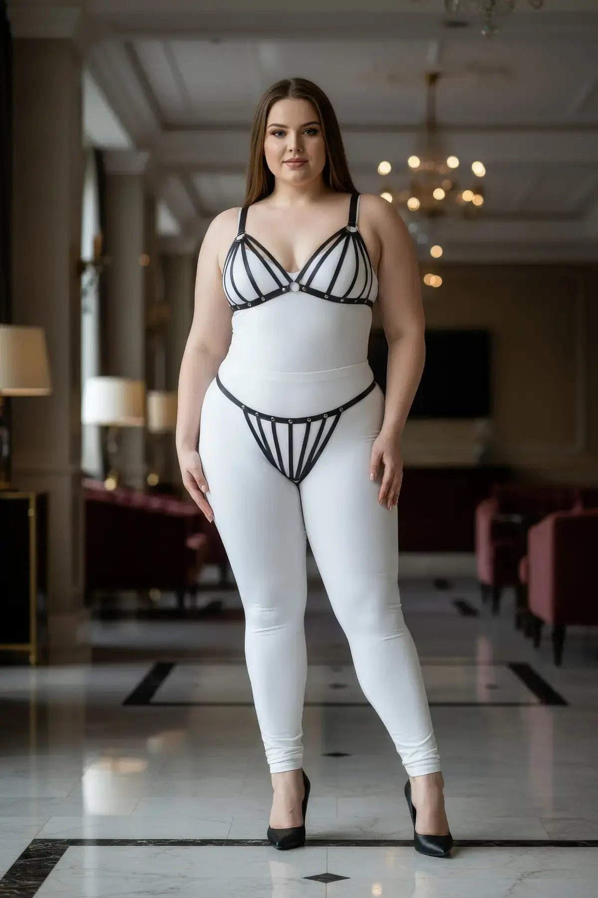 Plus Size Black Elastic Multi-Strap Fantasy Harness by HarnessClub worn over a white bodysuit.