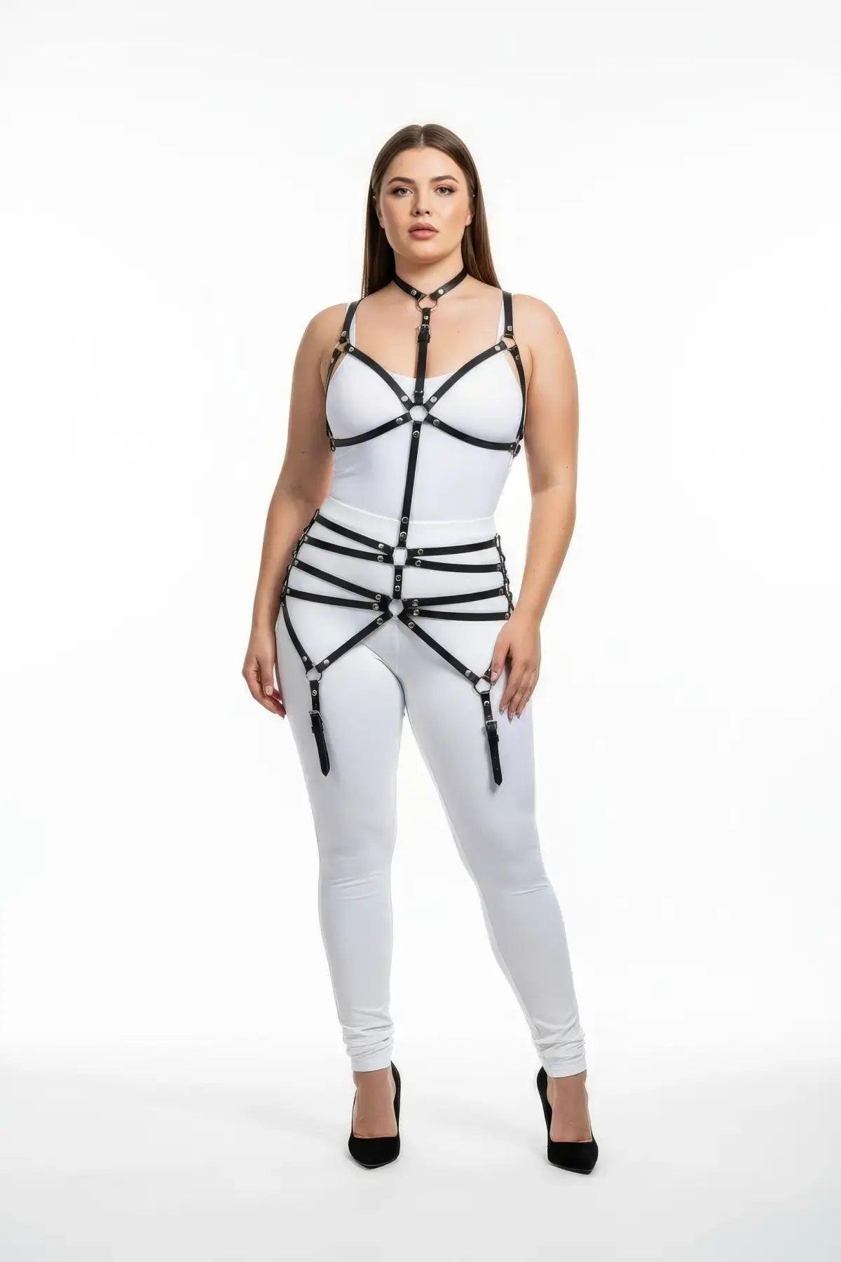 Plus-size black faux leather bustier garter harness worn by model over a white bodysuit; strappy vegan leather design