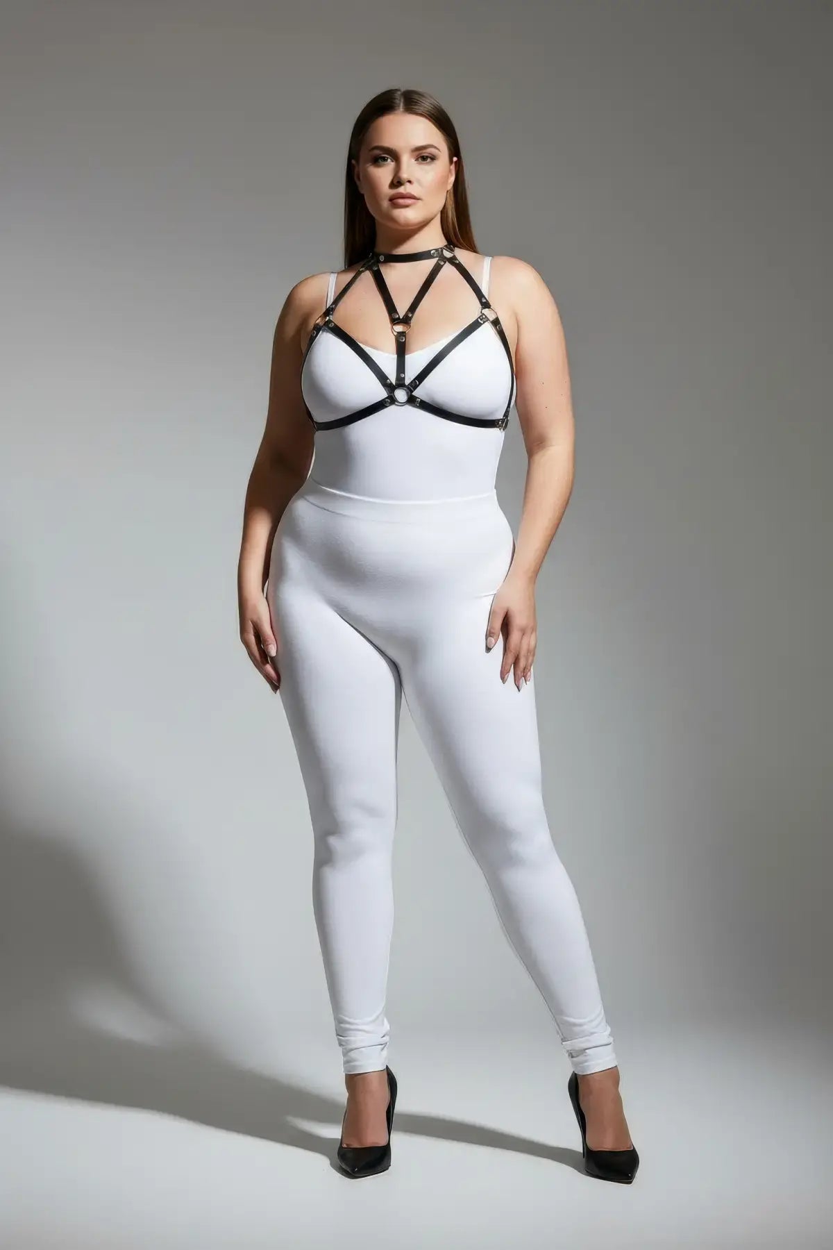 Plus Size Black Faux Leather Chest Harness by HarnessClub worn over a white bodysuit