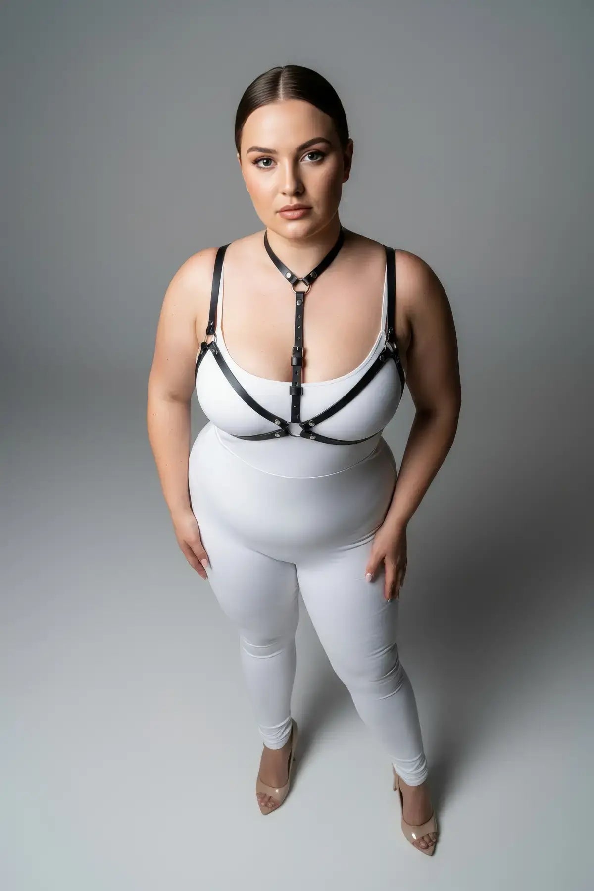 Plus Size Black Faux Leather Chest Harness worn over a white bodysuit by HarnessClub