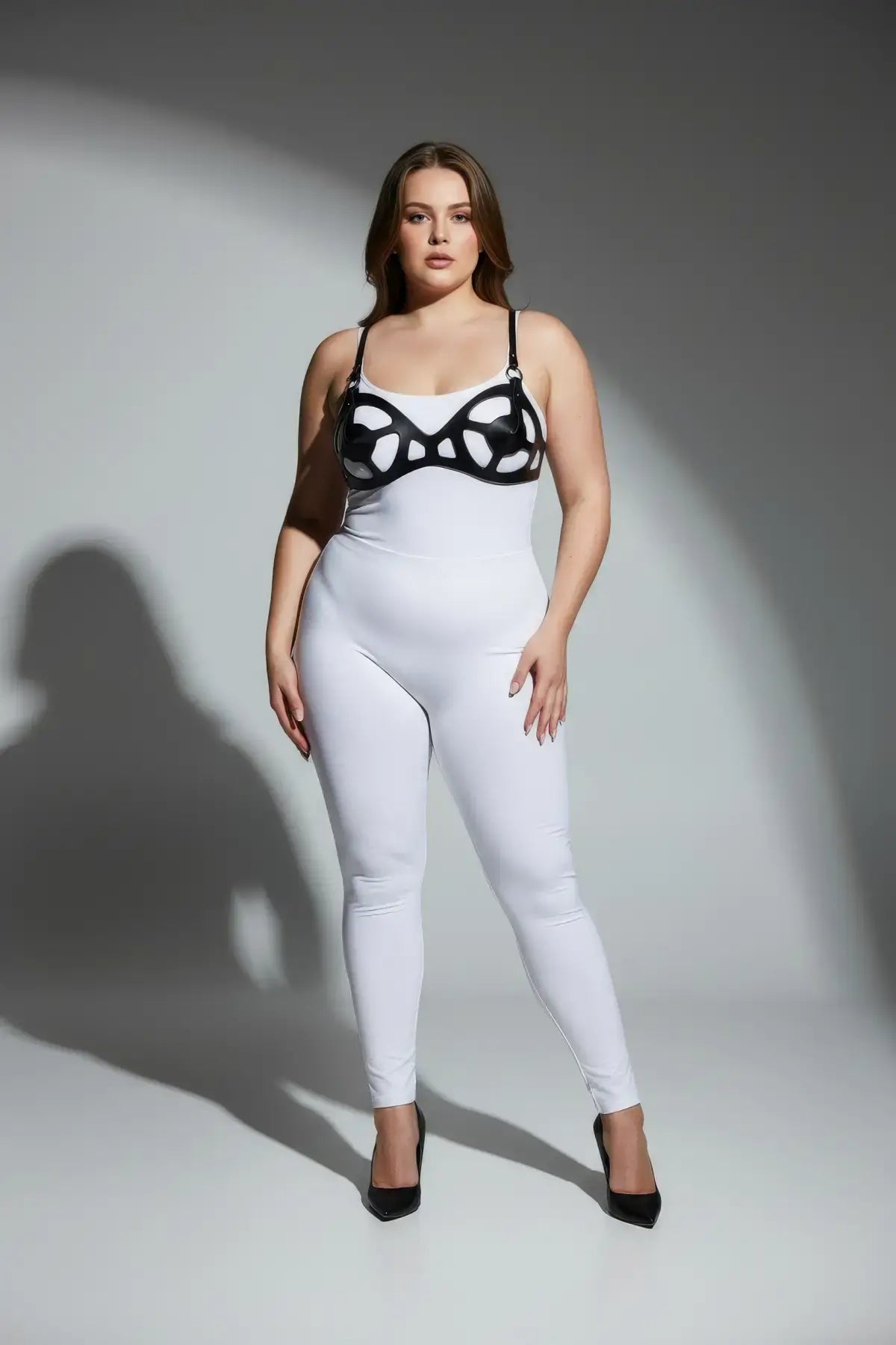 Plus size black faux leather fantasy body harness set worn over white bodysuit, HarnessClub.