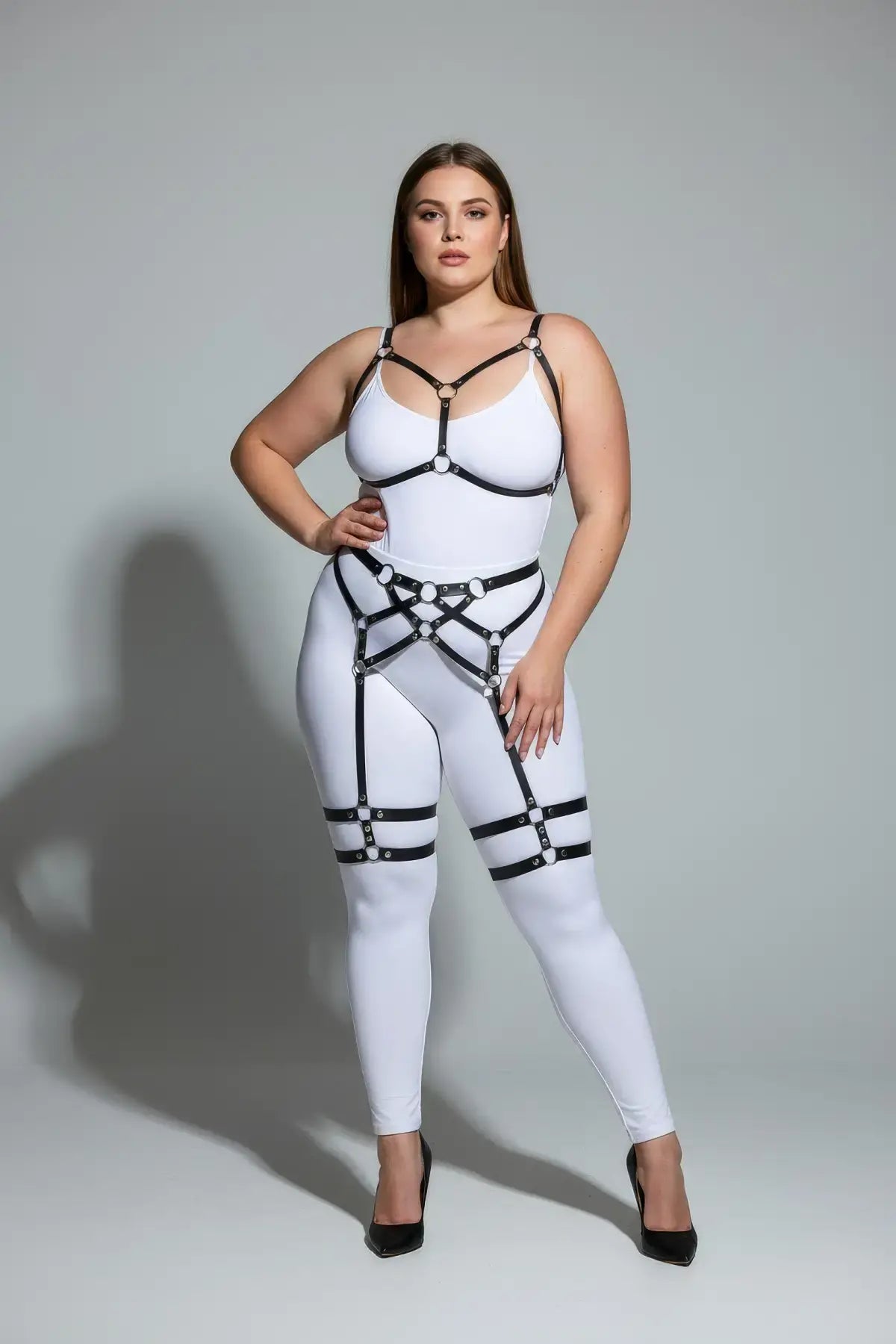 Plus-size white bodysuit with black faux-leather harness straps and garter harness