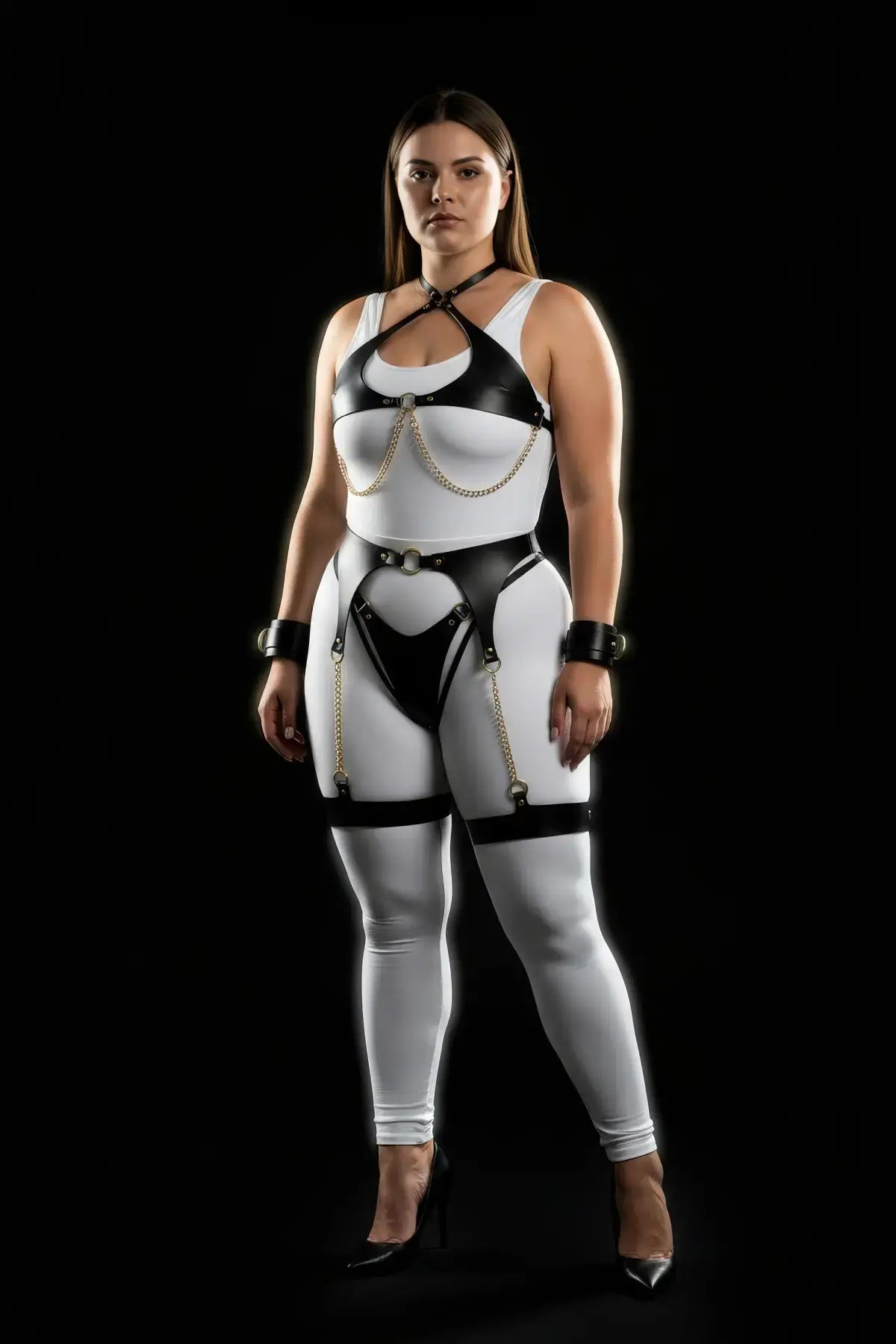 HarnessClub plus-size black vegan leather four-piece harness set with gold chains, garter belt, and wrist cuffs.