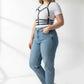 Plus-size black vegan leather halter chest harness with ribcage bands worn over a white tee.